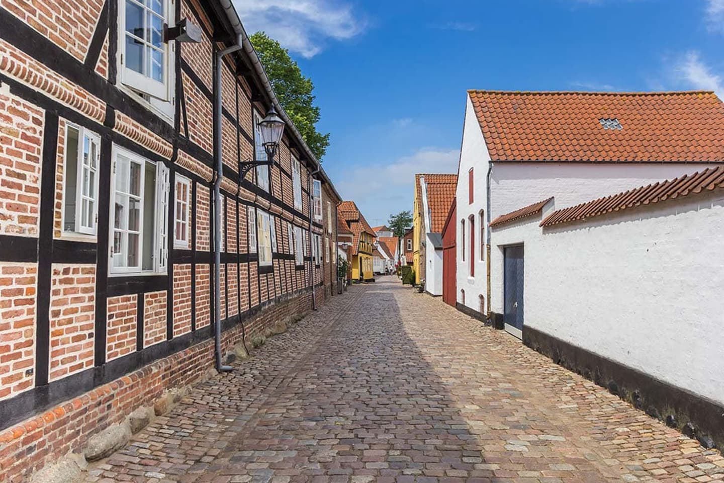 Kopfsteingepflasterte Gasse mit historischen Fachwerkhäusern und weiß verputzten Gebäuden in Peine – typische Altstadt, ideale Kulisse für regionale Zeitungszustellung und Lokalzeitung in Peine, Niedersachsen. - Lokalboten Hannover